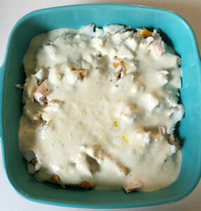 Flaked cooked fish in cheese sauce