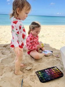 two kids painting on the beach in Barbados