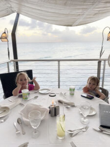Two kids having dinner by the ocean at Champers in Barbados