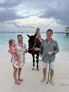 Family standing with a horse at Pebbles Beach Barbados