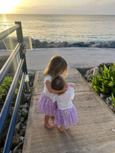 Two sisters cuddling at sunset in Barbados