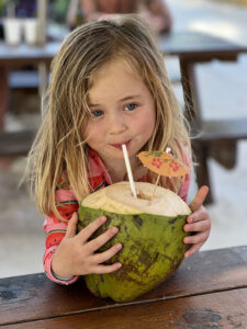 Girl drinking from a coconut in Barbados