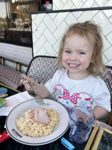 Lottie eating pasta at Brasserie Rosalie in the Disney Village